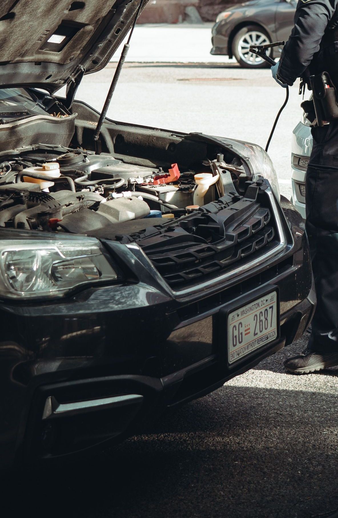 A police officer assists a car with a breakdown on the streets of Washington DC.